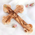 Promotional image of the back of a handcrafted budded olive wood cross with Stations of Cross written, placed on a white background.