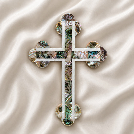 Handcrafted budded olive wood cross with green-white mother of pearl accents, on a white background