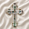 Handcrafted budded olive wood cross with green-white mother of pearl accents, on a white background
