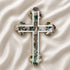Handcrafted budded olive wood cross with green-white mother of pearl accents, on a white background