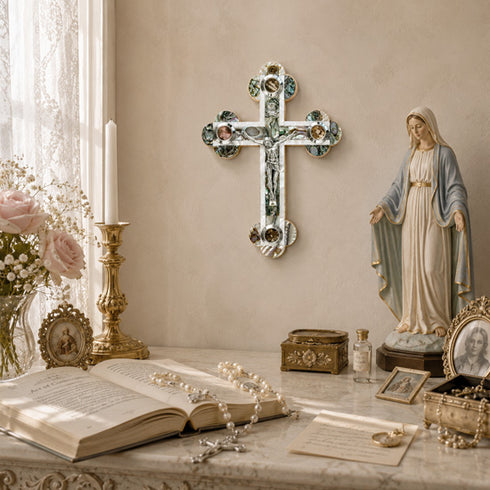 Decorative setup with a cross, statue of a religious figure, and books on a table.