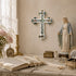 Decorative setup with a cross, statue of a religious figure, and books on a table.