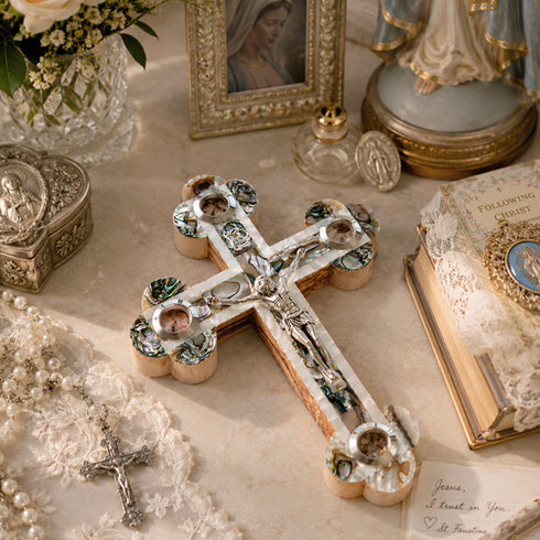 Decorative cross with Mother of Pearl on a table with religious items