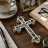 Decorative cross with Nacre on a wooden surface with a cup, book, and photo frame.