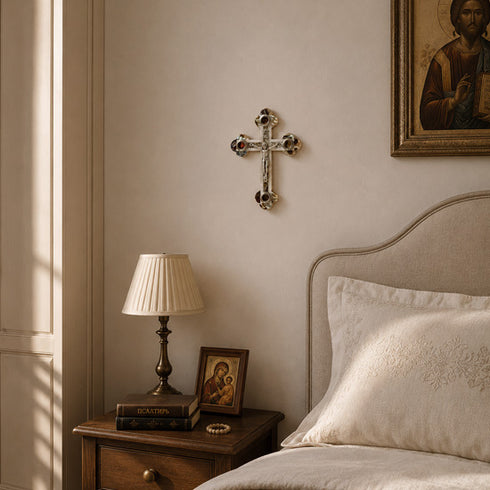Orthodox style bedroom with wooden nightstand, lamp, and framed pictures on a beige wall.