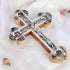 Full size handcrafted olive wood budded cross adorned with a detailed silver crucifix and colourful mother of pearl, resting on a clean white surface with scattered rose petals for a serene touch.