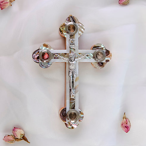 Frontal image of a hand-crafted Eastern cross made of rich olive wood, detailed with white mother of pearl inlay, silver crucifix, and the four sacred elements from the Holy Land.