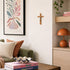 Living room with a green sofa, decorative pillows, a wooden shelf with a lamp, and a plant.