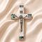 Small olive wood cross with crucifix, Nacre inlay and INRI plaque, laid on white surface.