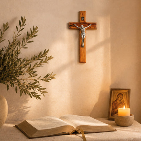 Wooden cross, open book, candle, and icon on a table with a neutral background