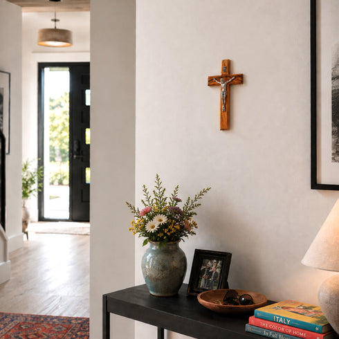 Home interior with a vase of flowers, books, and a crucifix on the wall.