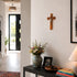 Home interior with a vase of flowers, books, and a crucifix on the wall.