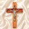 Wooden cross with a silver Jesus figure on a beige fabric background
