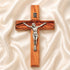 Wooden cross with a silver Jesus figure on a beige fabric background