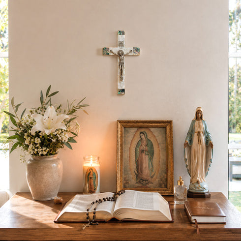 Religious items including a cross, statue, and open book on a table with a neutral background.