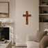 Living room with a fireplace, cross on the wall, and a couch with pillows.