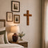 Nursery room with wooden cross, framed pictures, and lamp on a nightstand.