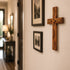 Wooden cross with engraved text on a wall in a home setting