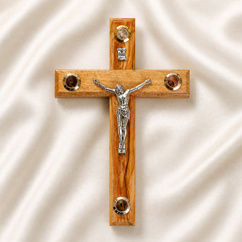 Medium size all-hanging olive wood Latin cross with carved edges, crucifix, Four Elements, on a white backdrop with petals.