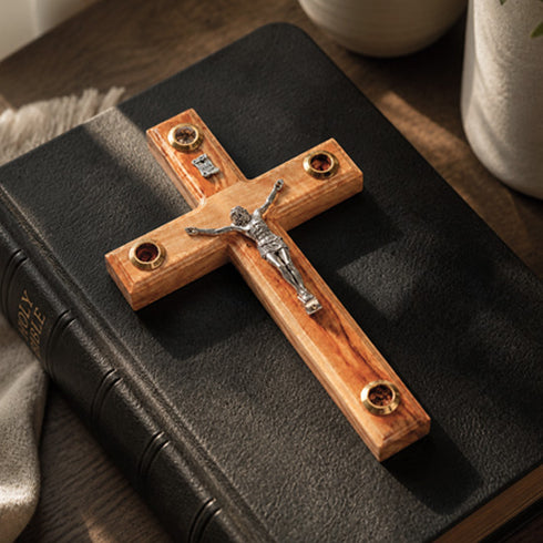 Wooden cross with Jesus figure on a black leather-bound Bible