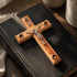 Wooden cross with Jesus figure on a black leather-bound Bible