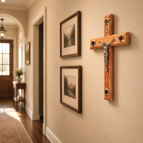 Wooden crucifix with Jesus Christ figure on a wall in a hallway with framed pictures.
