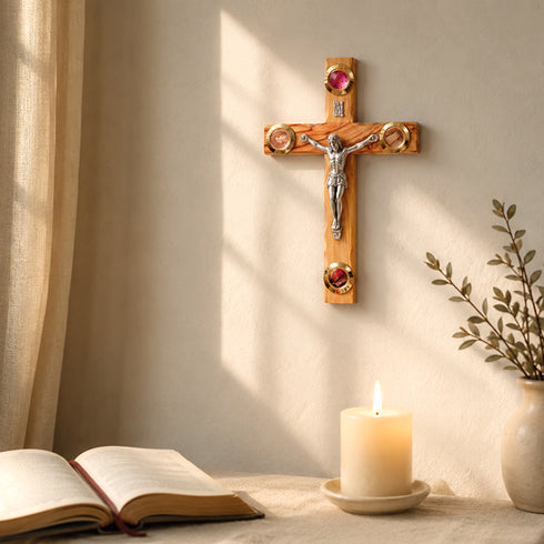 Wooden crucifix on a wall with an open book and lit candle below.