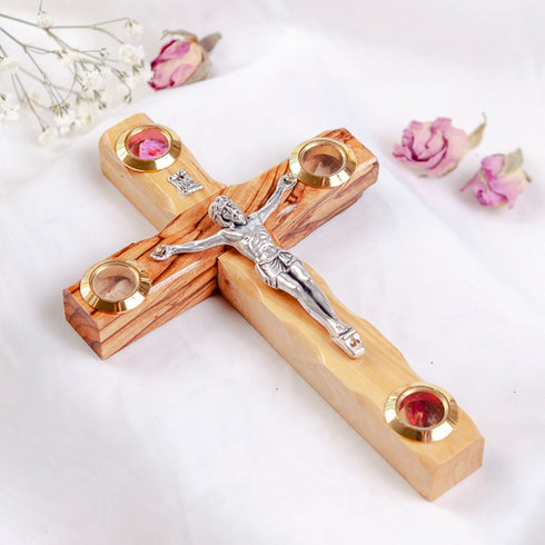 A handcrafted wooden crucifix with a natural olive wood, featuring Four Elements, on white surface.