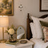 Bedroom with wooden crib, lamp, and decorative items on a shelf.