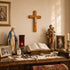 Religious items on a wooden altar including statues, cross, and open book.
