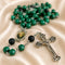 A rosary with green malachite beads, black lava stone beads, and a silver-tone crucifix.