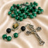 A rosary with green malachite beads, black lava stone beads, and a silver-tone crucifix.