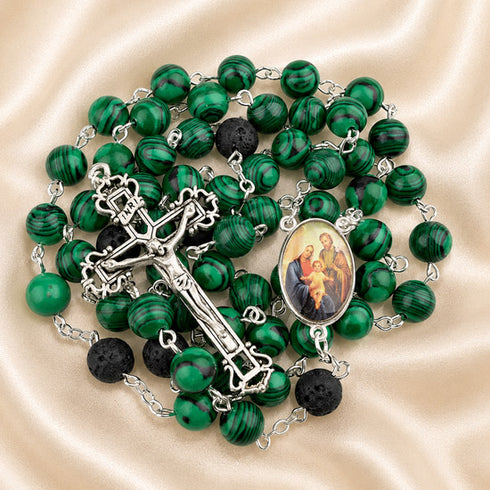 A green and black malachite rosary with a crucifix,and a medallion containing a religious image.
