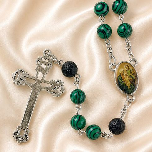 A rosary green marbled beads, black textured beads, a silver-tone cross, and an oval icon of the Holy Family.