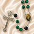 A rosary green marbled beads, black textured beads, a silver-tone cross, and an oval icon of the Holy Family.