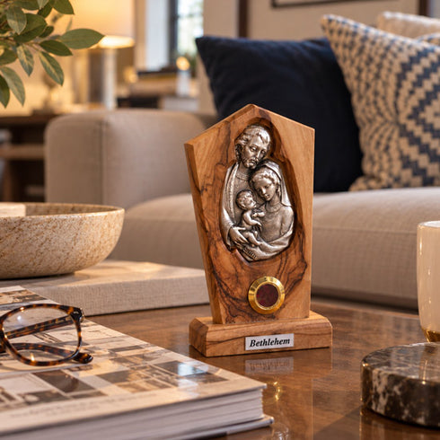 Holy Family olive wood plaque standing on a table in a warm home interior with soft natural light
