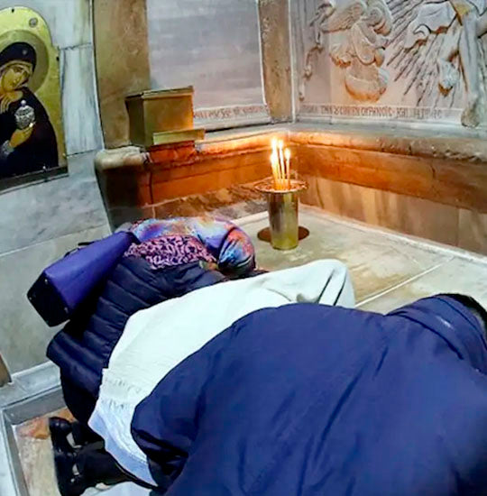 Pilgrims visiting and praying at the Most Holy Sepulchre inside the Aedicula.