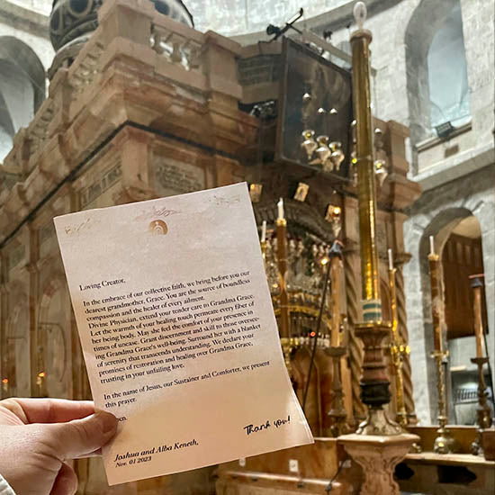 A person holding a written prayer request for the Aedicule of the Holy Sepulchre.