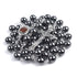 Black hematite rosary with Holy Soil centrepiece and a crucifix on a white background.