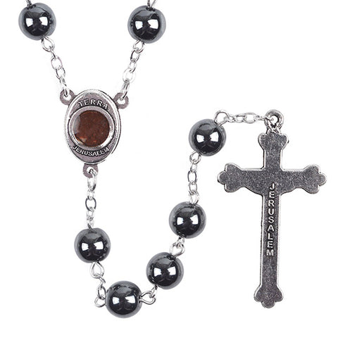 Rosary with black hematite, Holy Soil centrepiece and a cross on a white background