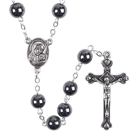 Black hematite rosary with Mary medal and a crucifix on a white background.