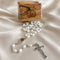 White pearl rosary with oval medallion and metal crucifix, olive wood box behind