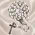 White pearl rosary with silver chain, oval medallion, and metal crucifix cross