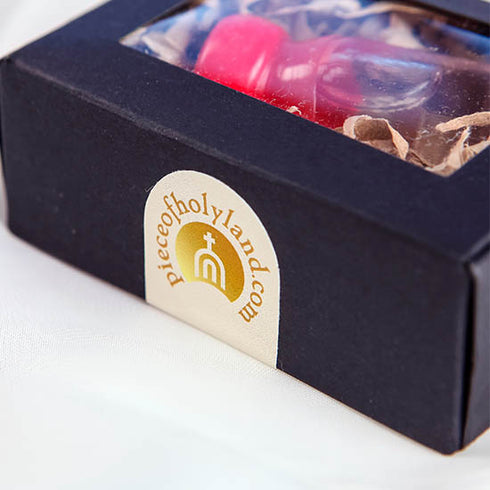 Product image of a Holy Water vial from the Holy Land with a red cap, elegantly presented in a black box with Piece of Holy Land.