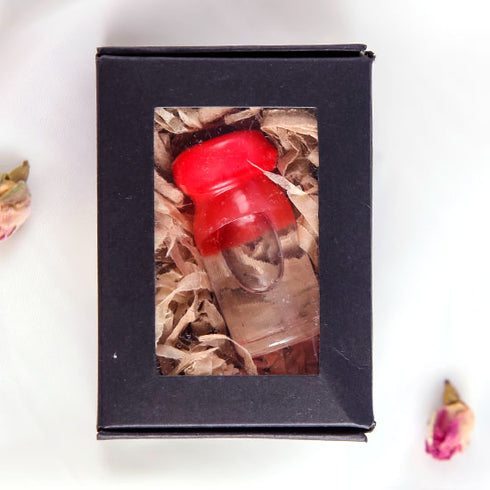 Product image of a Holy Water vial from the Holy Land with a red cap, elegantly presented in a black box.