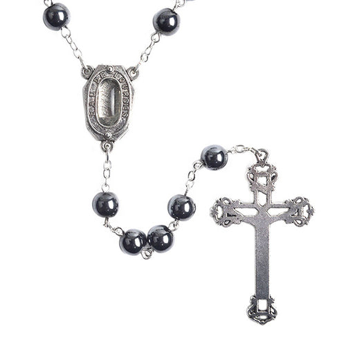 Black hematite rosary with a cross and Lourdes Holy Water medal on a white background.