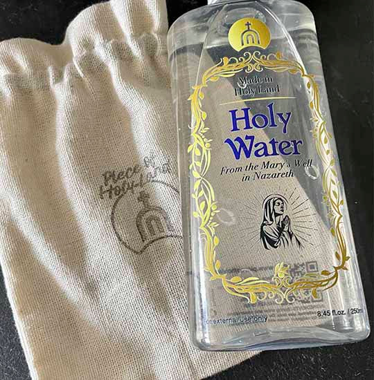 Plastic bottle of the Holy Water from Mary's Well with a light brown cotton bag.