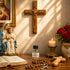 An altar with a wooden cross, a Virgin Mary and baby Jesus statue, rosary, a Holy Water bottle, a Bible, a lit candle, and red roses