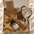 A Holy Water, a rosary and Cross gift set presented in a white box with shredded paper.