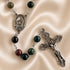 A rosary with dark green, black, and burgundy beads, featuring a silver-toned medallion of Saint Charbel and an ornate crucifix.